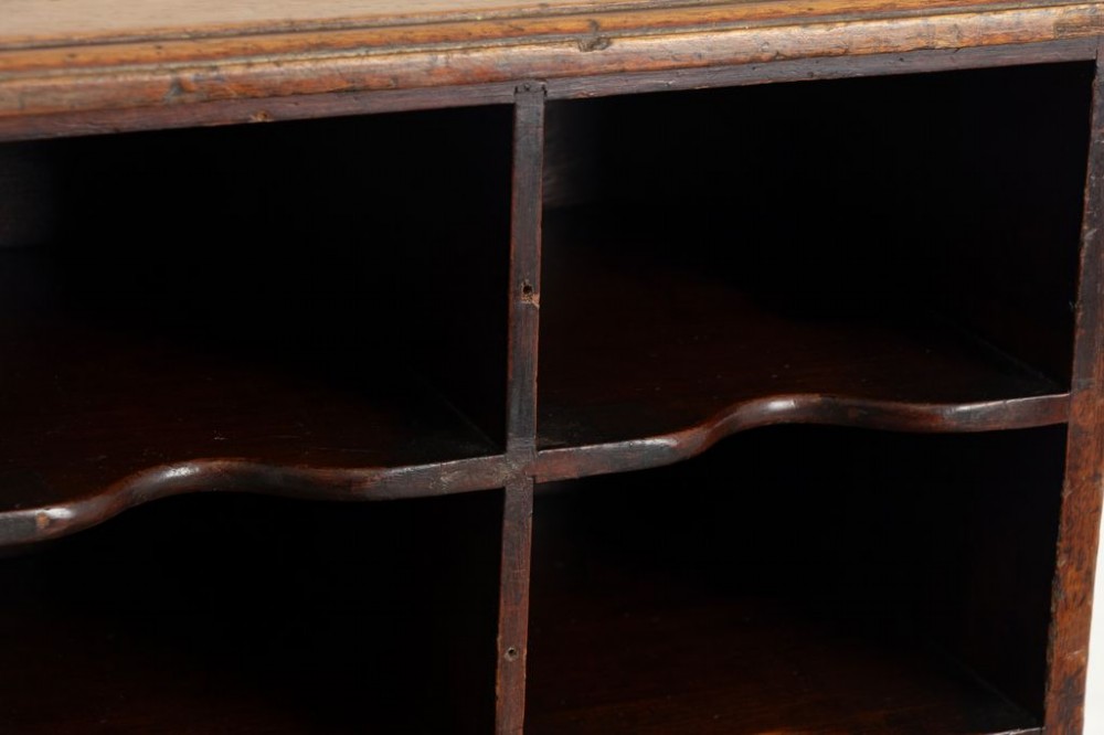 A 19th-century dark mahogany desktop pigeon hole unit featuring twenty-four open rectangular compartments with contoured shelf edges. View III