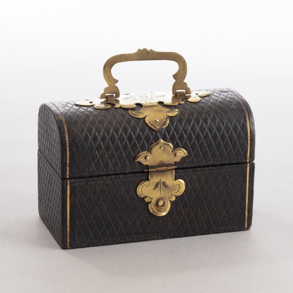 An open black leather box lined with purple velvet containing three clear glass perfume bottles with octagonal faceted stoppers. View III