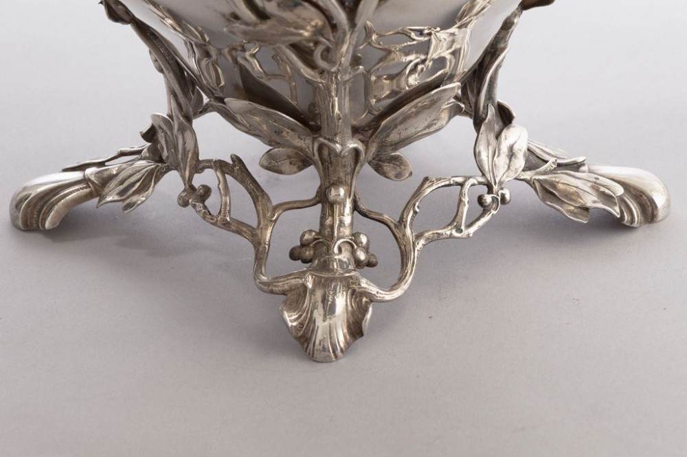 A silver-plated Art Nouveau champagne bucket featuring floral relief details, whiplash tendrils, sculpted handles with female heads, and a pierced footed base. View III