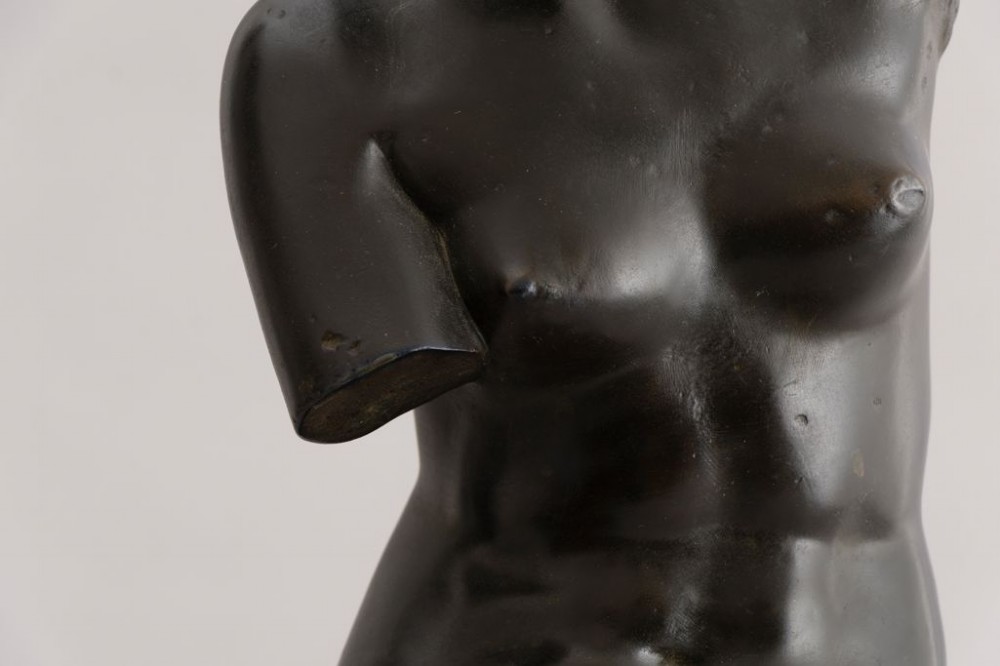 A dark brown bronze sculpture depicting the Venus de Milo draped in cloth around the lower body, mounted on an integrated rectangular base. View II