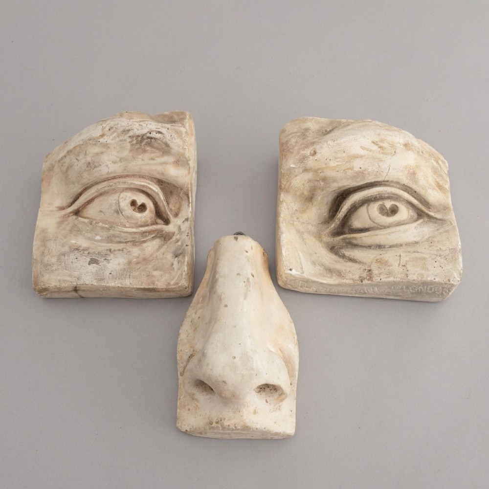 Three 19th-century aged off-white plaster casts displaying sculpted anatomical features including eyes and a nose after Michelangelos David. View II