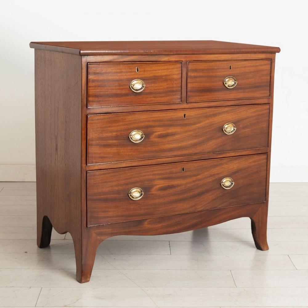 A small Georgian mahogany chest of drawers featuring two short drawers over two long drawers with brass oval handles and splayed feet. View II