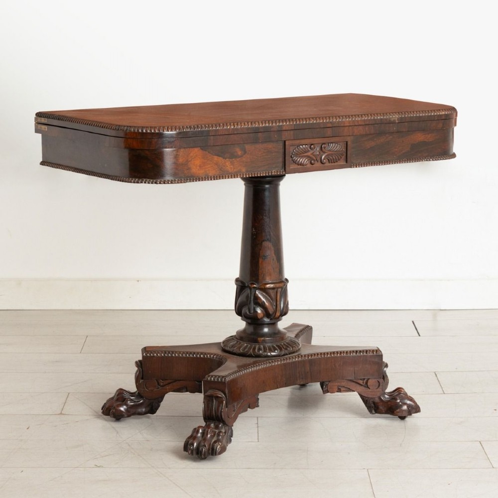 An antique mahogany gaming table featuring an unfolded green baize playing surface supported by a central carved pedestal stem and quadform base. View II
