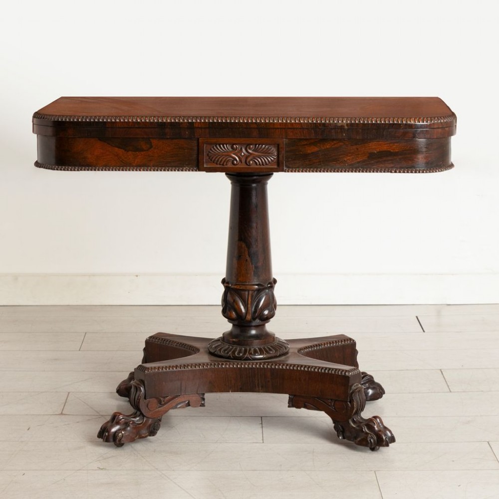 An antique mahogany gaming table featuring an unfolded green baize playing surface supported by a central carved pedestal stem and quadform base. View III