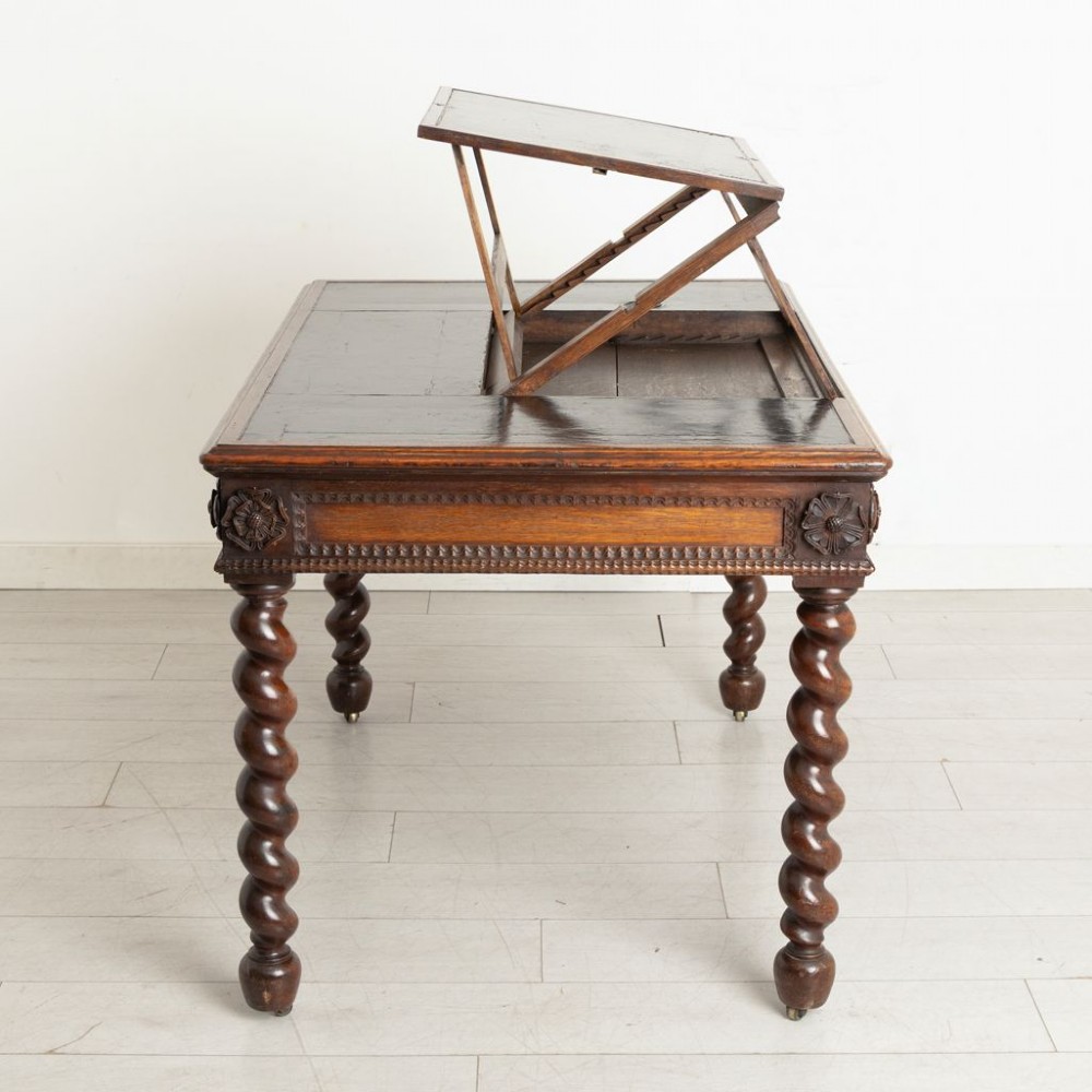 A nineteenth-century dark oak Neo-Jacobean architect desk with barley twist legs, carved decorative frieze, and an adjustable central leather writing slope. View III