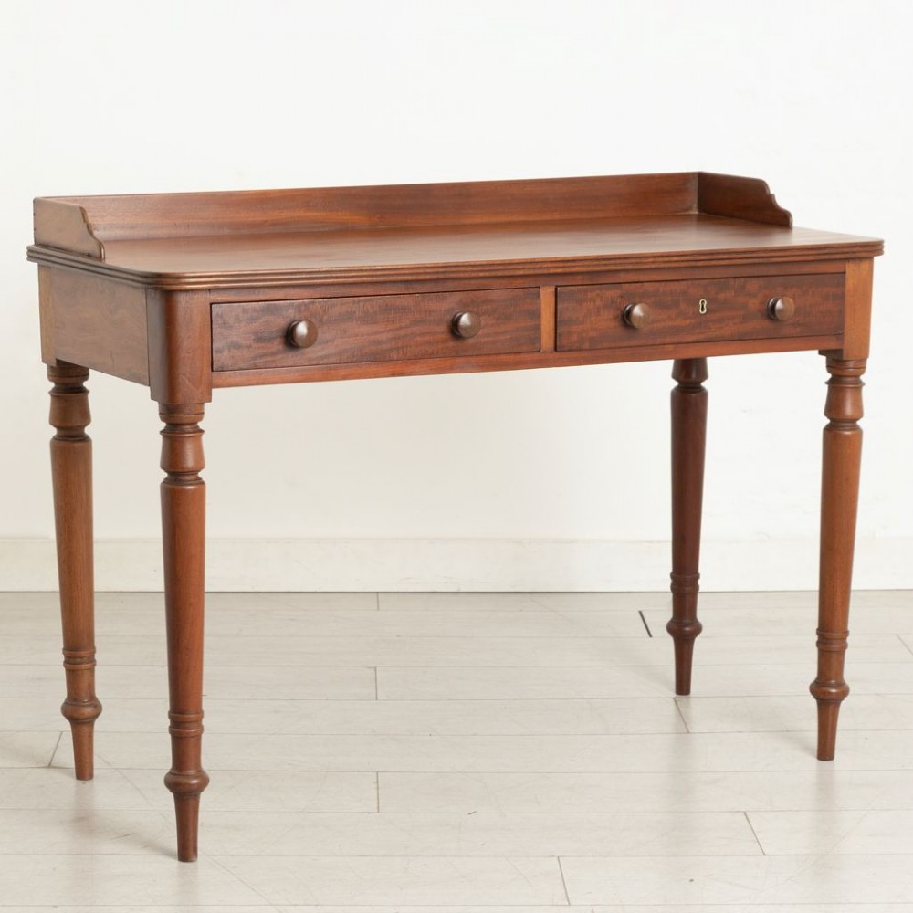 A 19th-century solid mahogany writing table featuring two frieze drawers with turned wooden handles and a low rear gallery. View II