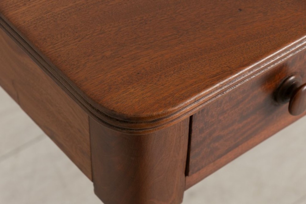 A 19th-century solid mahogany writing table featuring two frieze drawers with turned wooden handles and a low rear gallery. View III