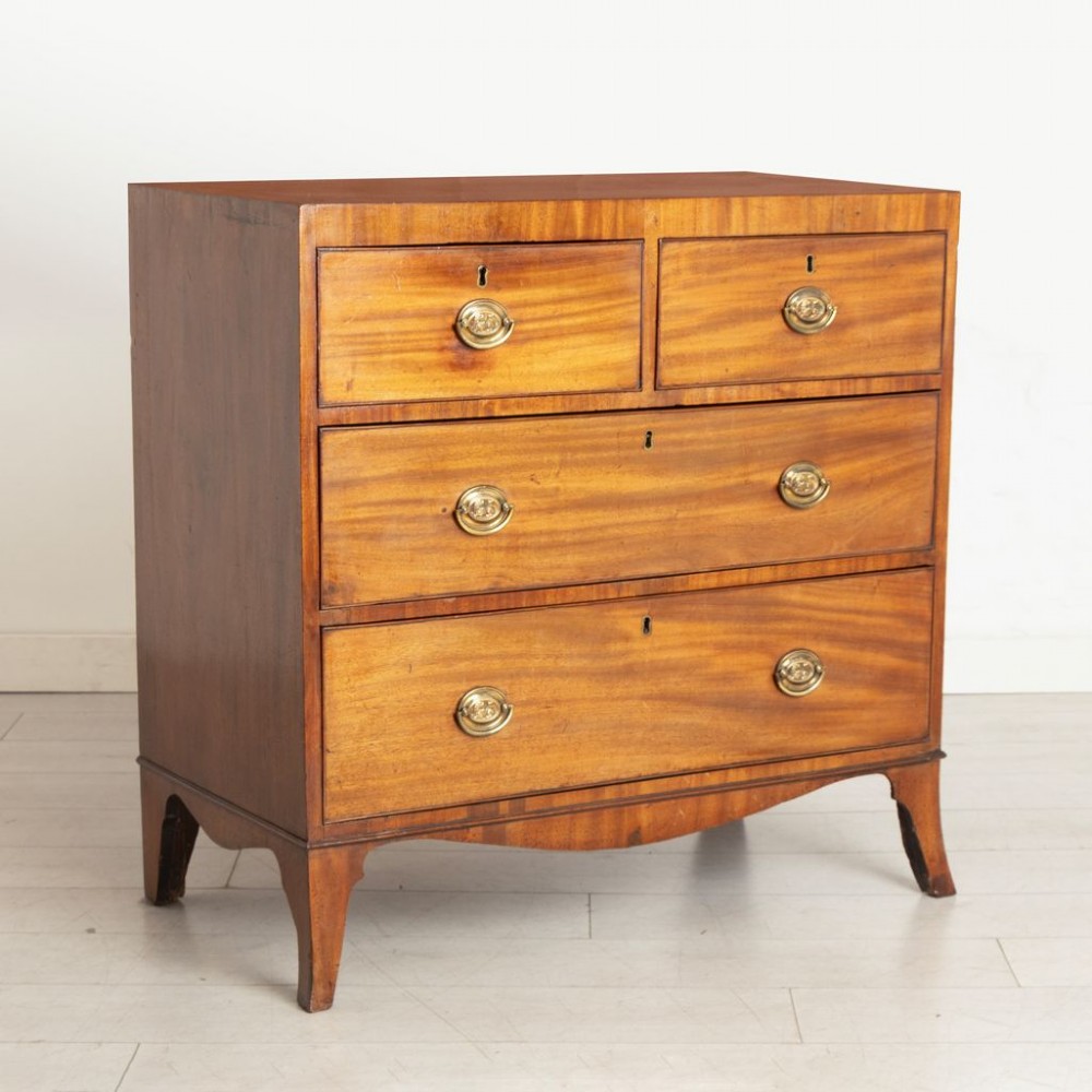 An antique Regency mahogany chest of drawers featuring two short drawers above two long drawers with brass handles and splayed bracket feet. View II