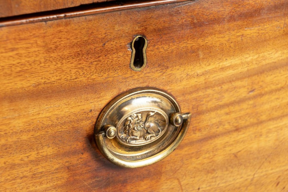 An antique Regency mahogany chest of drawers featuring two short drawers above two long drawers with brass handles and splayed bracket feet. View III