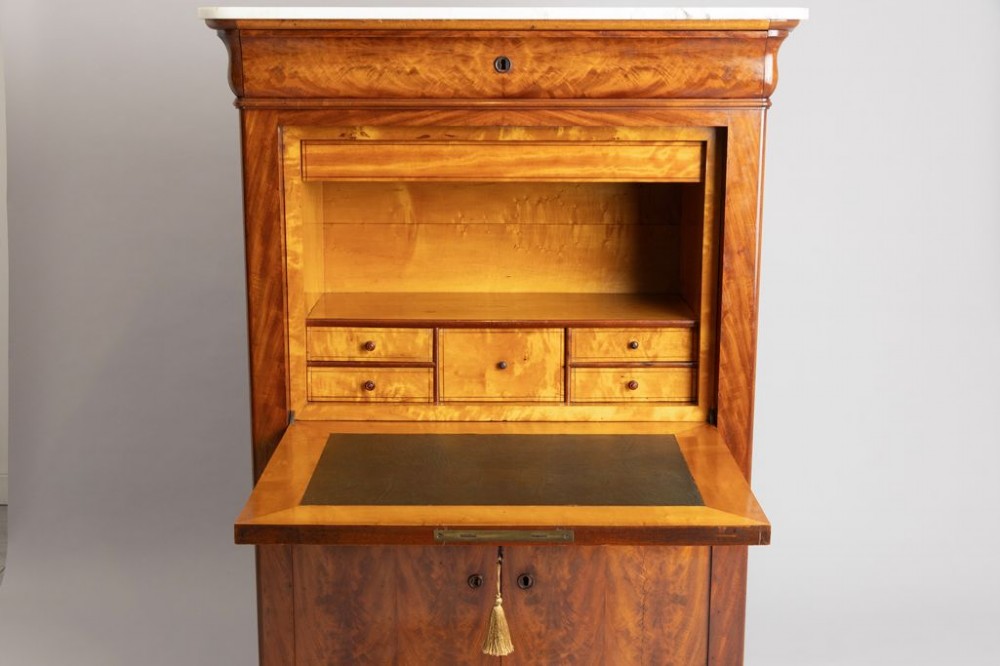 A 19th-century French Louis Philippe flame mahogany secretaire a abattant featuring a white marble top, upper frieze drawer, drop-front writing flap, and lower double doors. View III