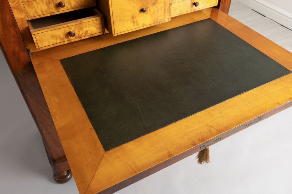 A 19th-century French Louis Philippe flame mahogany secretaire a abattant featuring a white marble top, upper frieze drawer, drop-front writing flap, and lower double doors. View IV