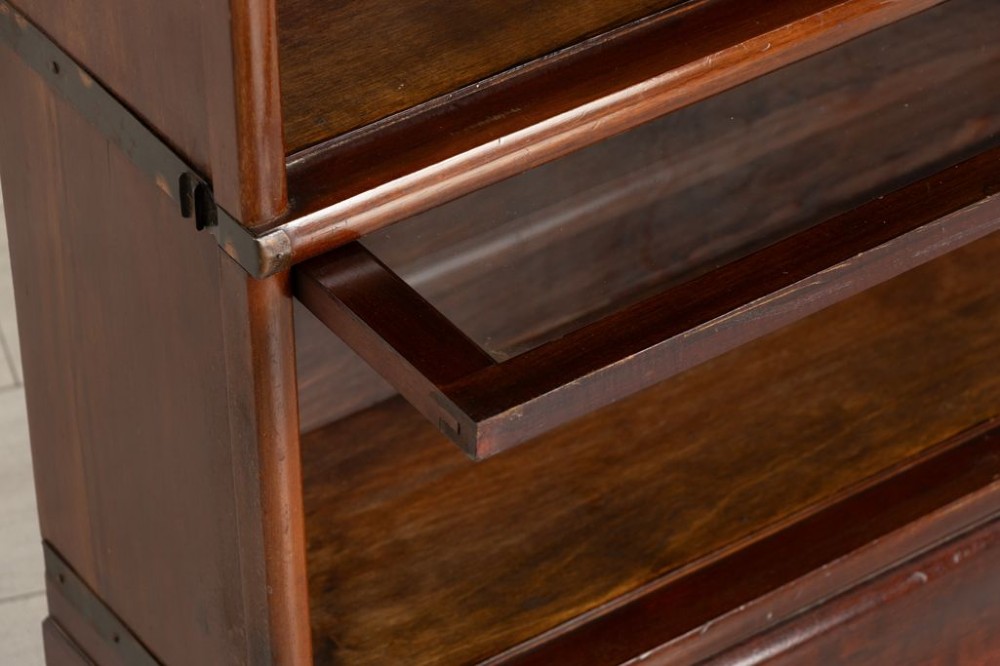 An antique mahogany three-tier Globe Wernicke sectional bookcase featuring glass up-and-over doors and a base drawer. View II