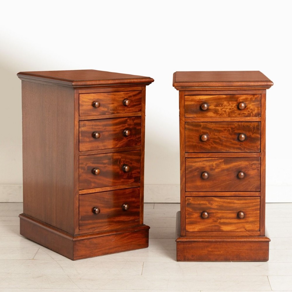 A matching pair of 19th-century Victorian mahogany bedside chests, each featuring four drawers with turned wooden handles and a plinth base.