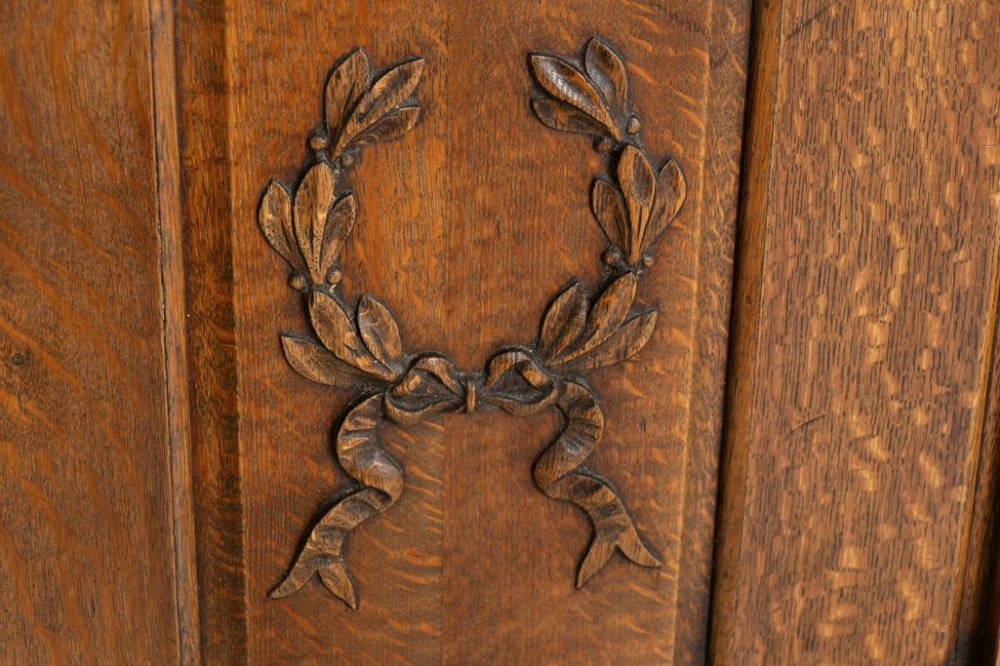 A late nineteenth-century oak side cupboard featuring a single panelled door decorated with a carved laurel wreath motif and flanked by fluted pilasters. View III