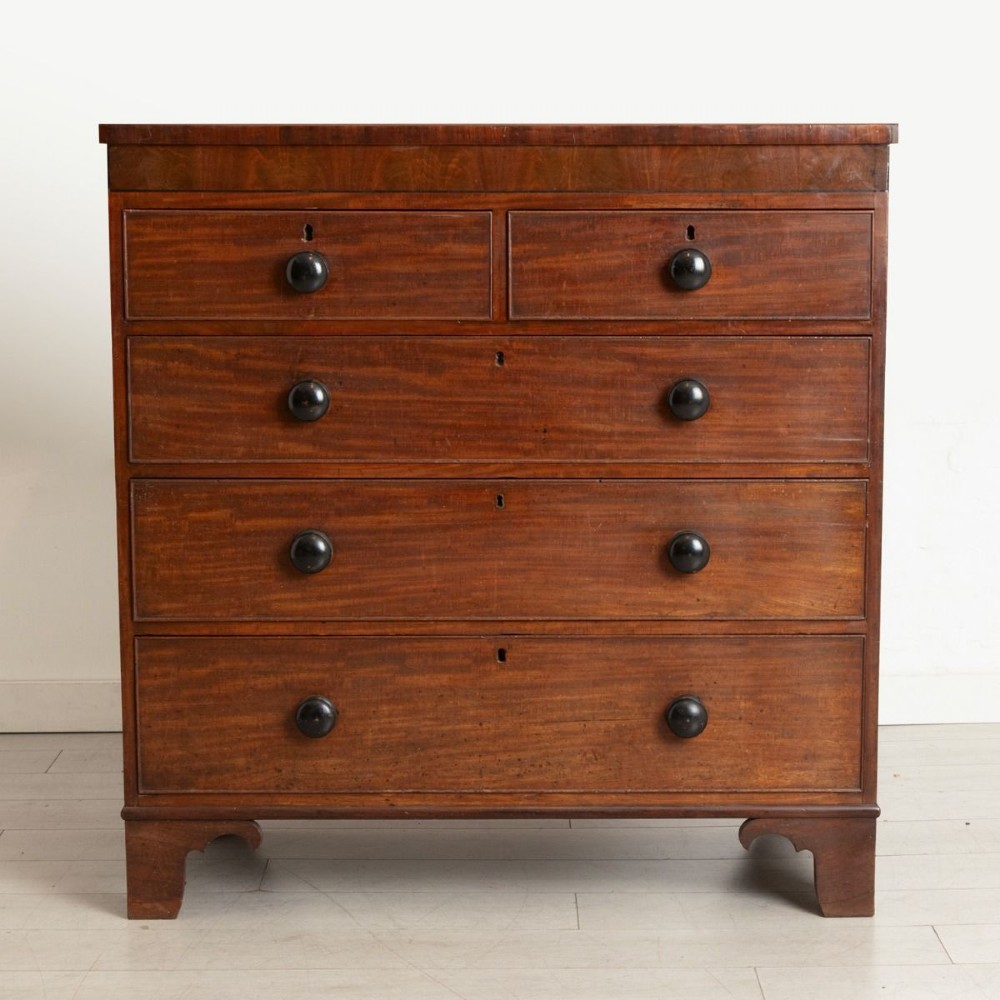 Victorian mahogany chest of drawers featuring two short drawers over three long drawers with dark turned knobs and shaped bracket feet.