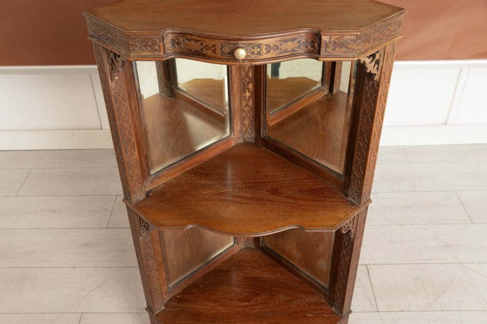 A pair of late 19th-century mahogany corner display cabinets featuring mirrored back panels, carved open shelves, and turned legs. View II
