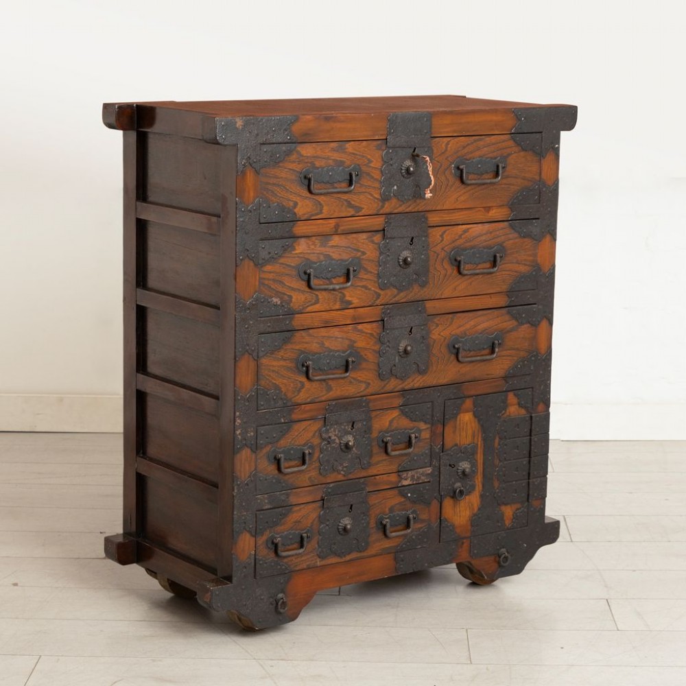 An antique Japanese zelkova wood chest of drawers featuring dark iron corner brackets, lock plates, drop handles, and integrated wooden wheels at the base. View II