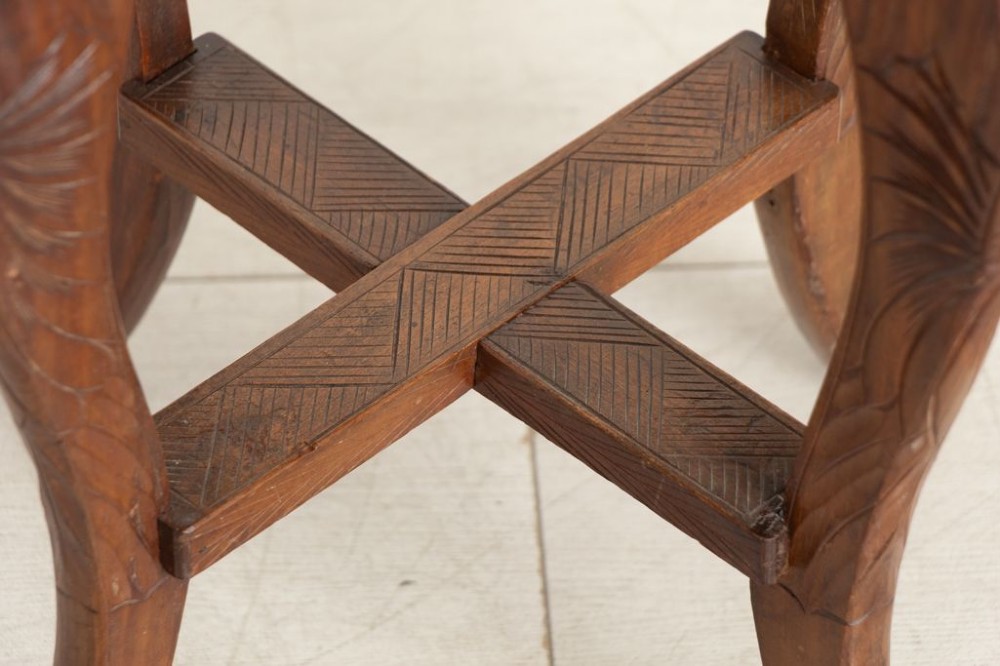 An antique hand-carved wooden side table featuring floral chrysanthemum motifs on the square top and curved legs joined by an X-stretcher. View III