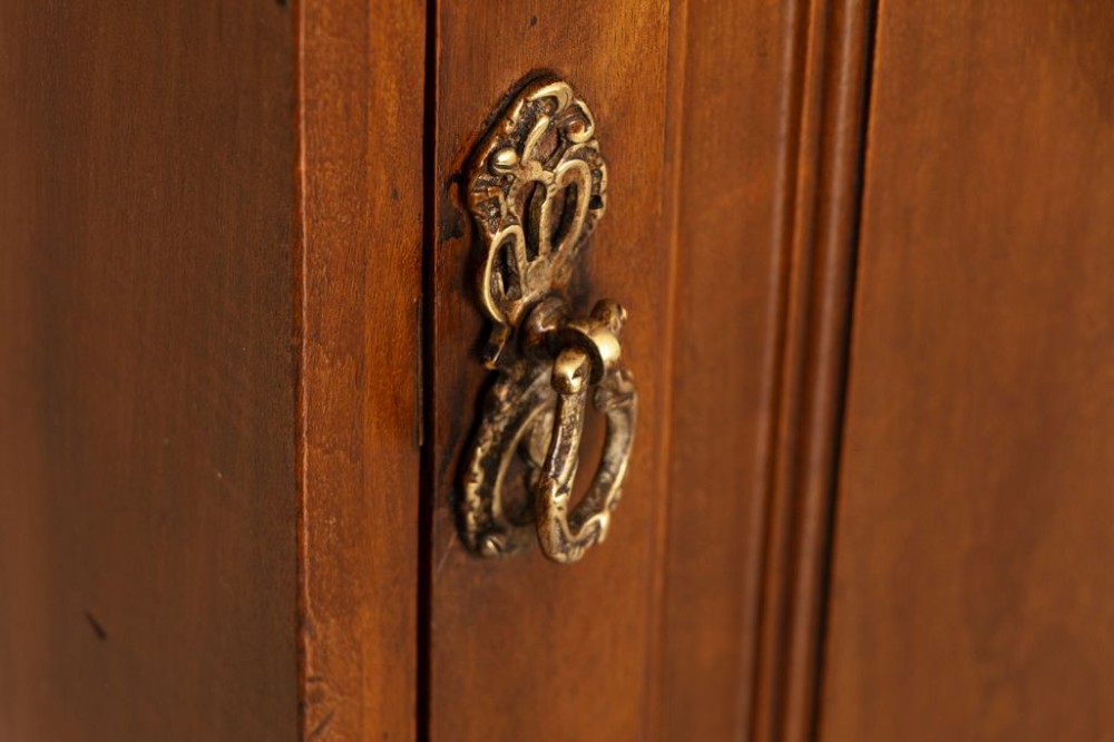 A pair of late Victorian mahogany bedside cabinets featuring single doors with carved fielded panels and brass drop handles on plinth bases. View II