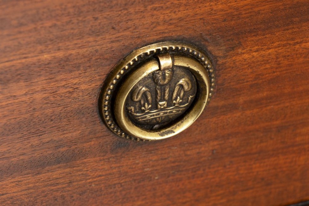 A Georgian mahogany chest of three long drawers featuring brass ring handles, escutcheons, and a scalloped apron resting on bracket feet. View III