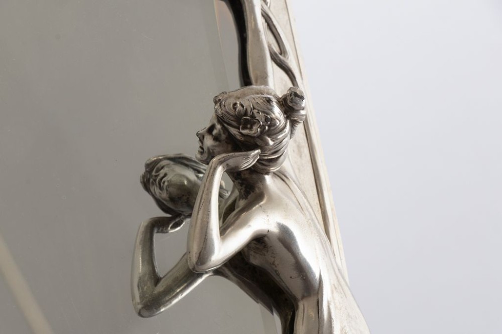 An Art Nouveau pewter easel-backed mirror featuring a sculptured maiden figure and relief floral motifs around a rectangular glass frame. View III