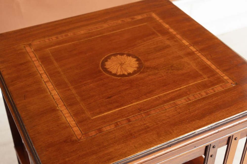 An Edwardian mahogany revolving bookcase featuring two tiers with vertical slatted sides, central rotating mechanism, and a quadruped base on castors. View III