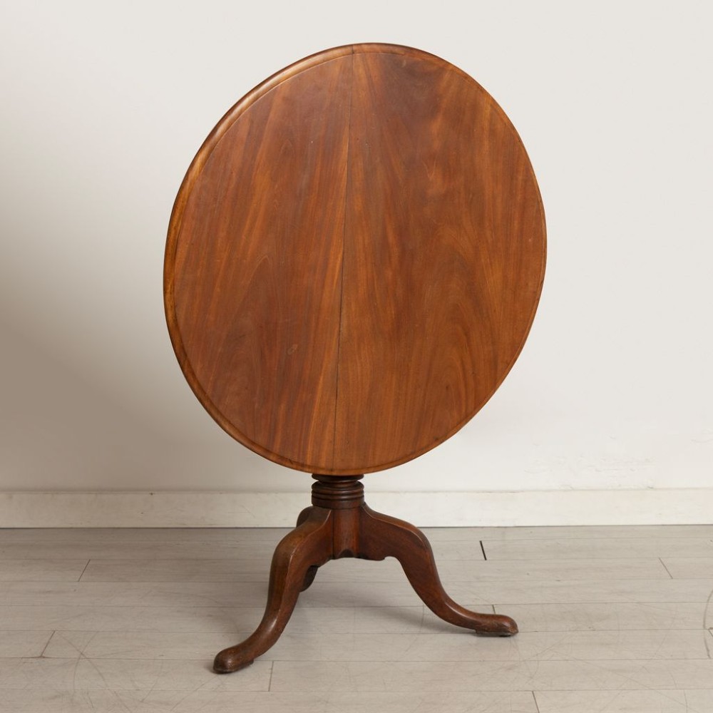 A nineteenth-century mahogany tilt-top table featuring a circular top mounted on a turned pedestal column with a tripod base. View II
