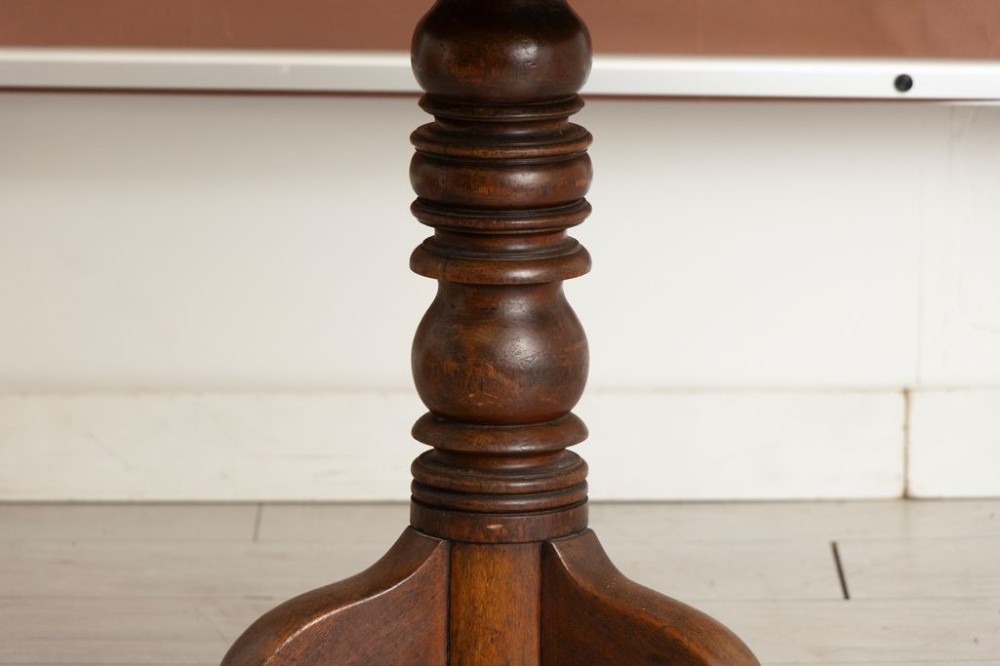 A nineteenth-century mahogany tilt-top table featuring a circular top mounted on a turned pedestal column with a tripod base. View III