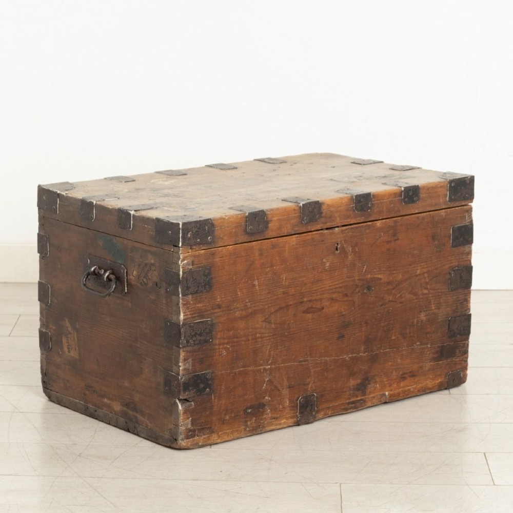 A rectangular Victorian pine travel trunk featuring iron corner straps, a front keyhole, and stencilled black text across the top lid. View II