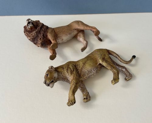 fig 1. A pair of cold-painted bronze statuettes depicting a male lion and a lioness in realistic tawny brown tones.
