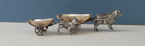 fig 1. A pair of antique silver novelty pin cushions featuring detailed dog figures pulling mother-of-pearl shell carts on two wheels.