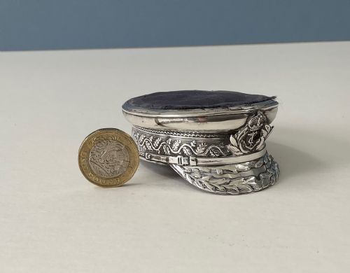 fig 1. An antique sterling silver novelty pin cushion rendered in the detailed form of a Royal Navy officers cap with a dark fabric top.
