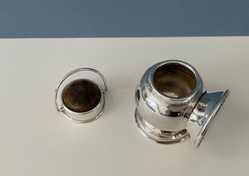 fig 1. An antique silver novelty pin cushion shaped like a miniature railway lantern with a round convex lens and a dark fabric cushion top.