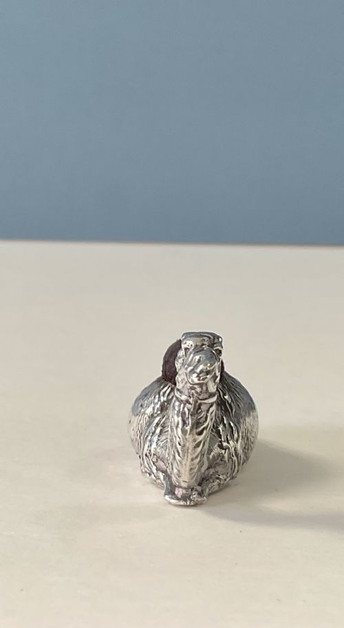 An antique silver novelty pin cushion cast in the form of a seated camel with a dark fabric cushion integrated into its back. View IV