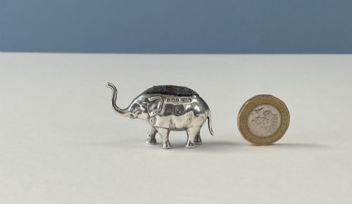 fig 1. A miniature silver novelty pin cushion cast in the shape of an elephant with a dark fabric insert set into its back.