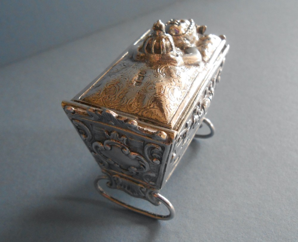 An Edwardian silver novelty snuff box crafted in the form of a miniature wicker cradle with a sleeping infant figure on the hinged lid. View V