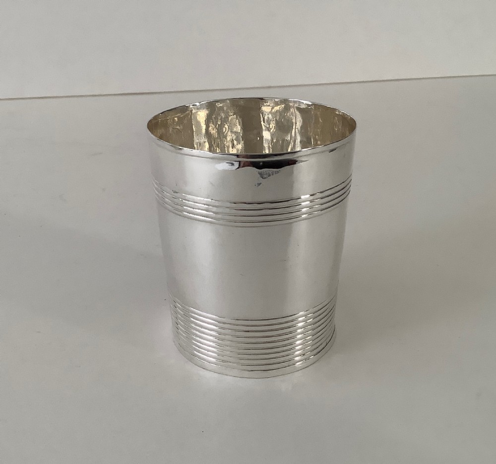 A cylindrical sterling silver beaker featuring horizontal reeded bands around the upper and lower exterior. View II