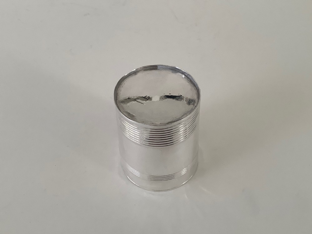 A cylindrical sterling silver beaker featuring horizontal reeded bands around the upper and lower exterior. View III