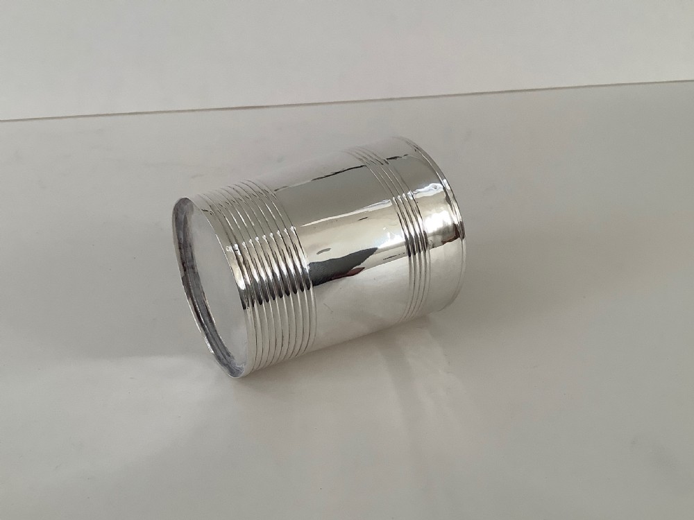 A cylindrical sterling silver beaker featuring horizontal reeded bands around the upper and lower exterior. View IV