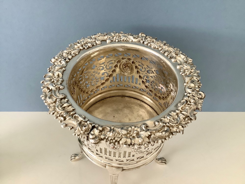 An antique silver-plated elevated wine coaster featuring pierced reticulated sides, a lion mask medallion, and tripod legs ending in claw feet. View VIII
