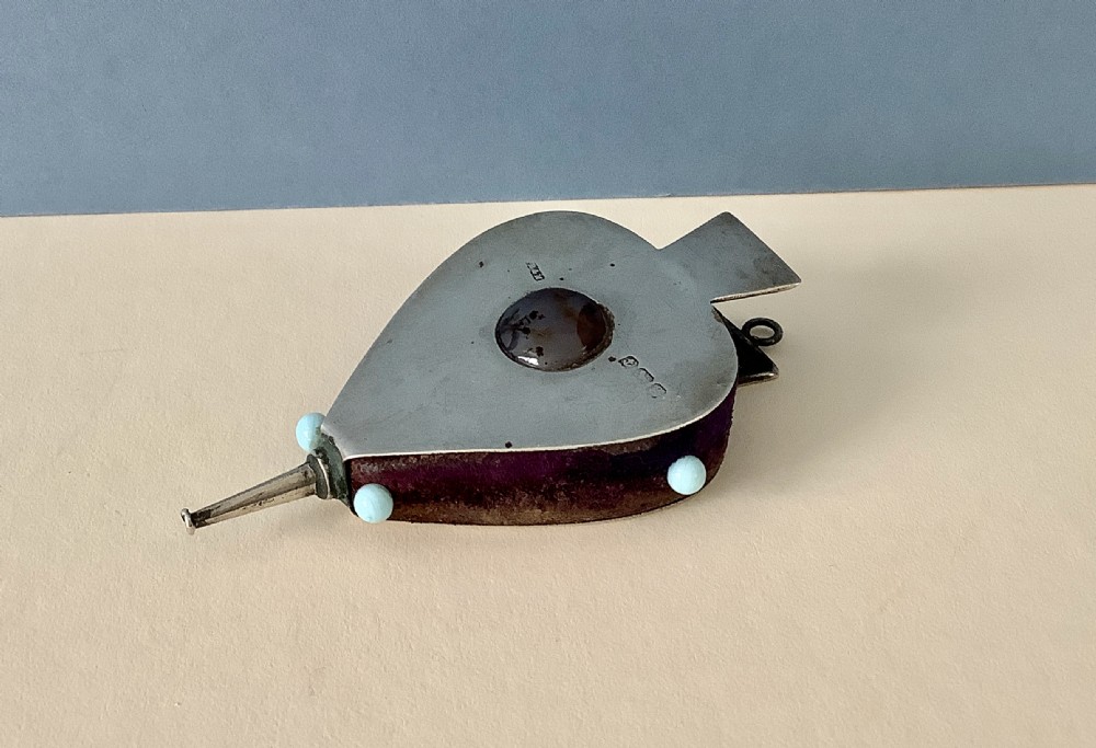 An Edwardian sterling silver pin cushion shaped as a pair of bellows with a central agate cabochon and a purple velvet core. View IV