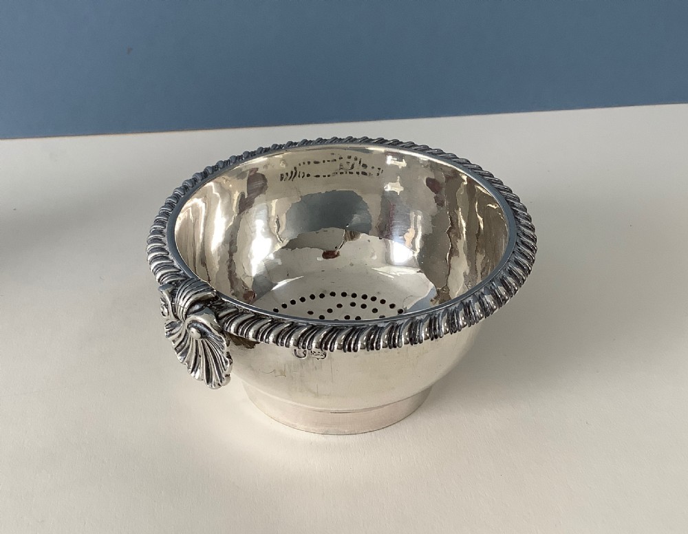 A three-part Georgian solid silver wine funnel featuring a perforated bowl with gadrooned rim, a retaining ring, and a curved spout. View III