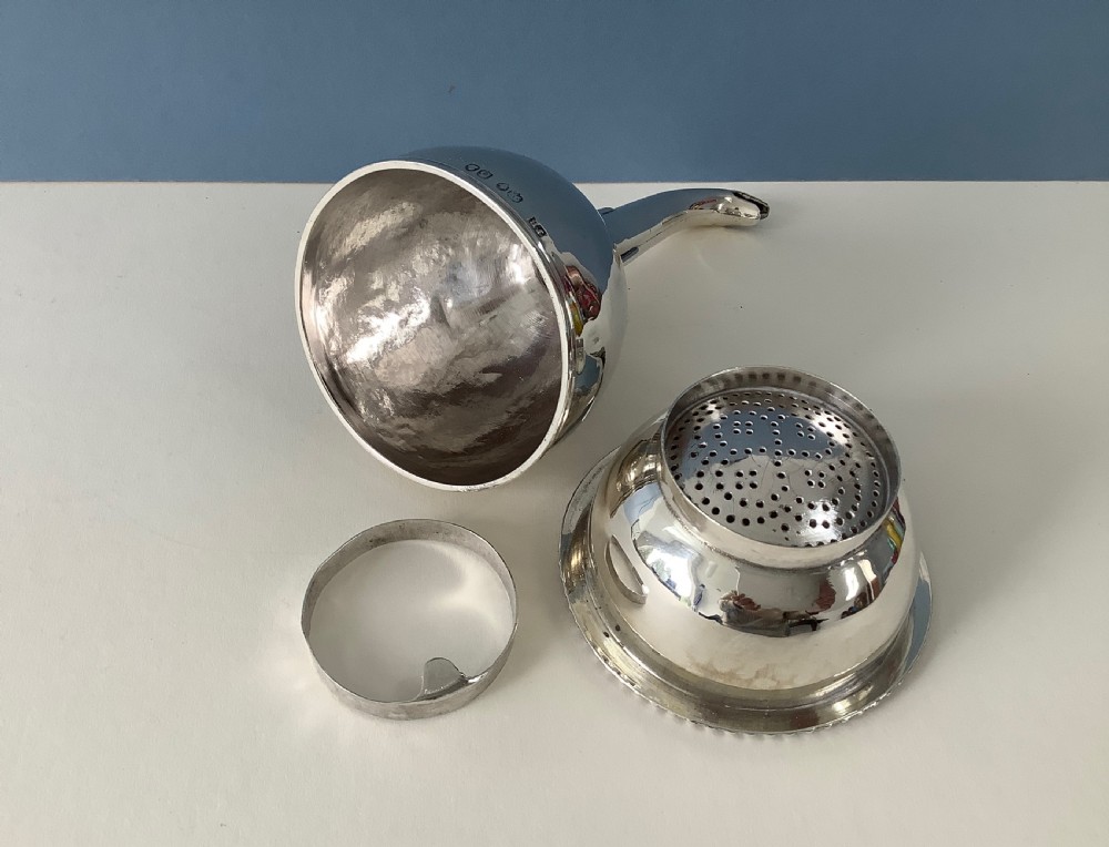 A three-part Georgian solid silver wine funnel featuring a perforated bowl with gadrooned rim, a retaining ring, and a curved spout. View VI