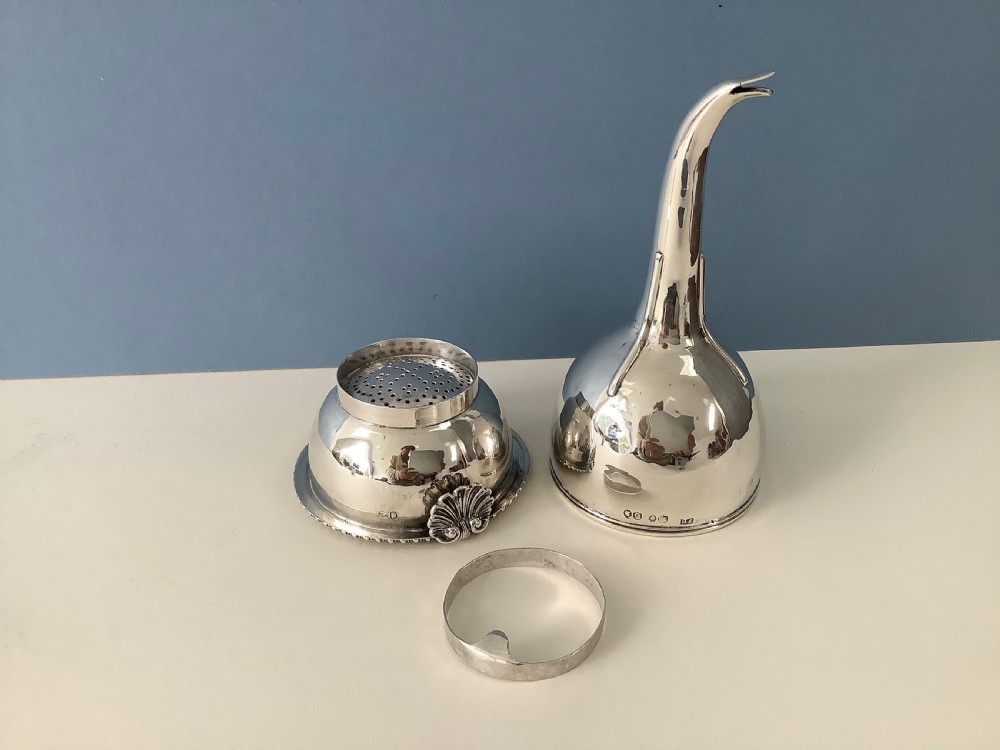 A three-part Georgian solid silver wine funnel featuring a perforated bowl with gadrooned rim, a retaining ring, and a curved spout. View VIII
