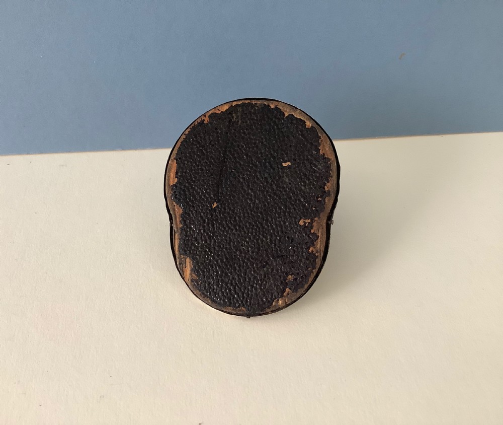 An antique silver pin cushion crafted in the form of a jockey cap with ribbed silver details, purple velvet fabric panels, and hallmarks stamped on the front brim. View VI