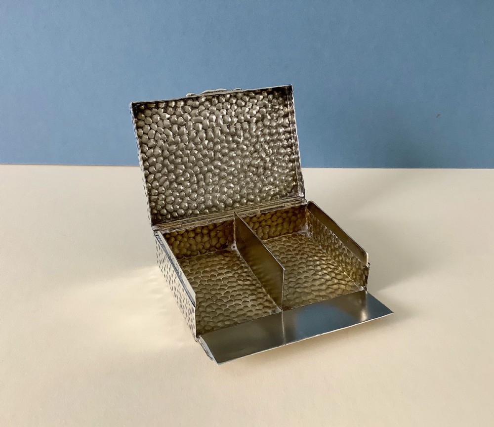A hammered silver playing card box displayed open with two decks of illustrated playing cards inside. View II