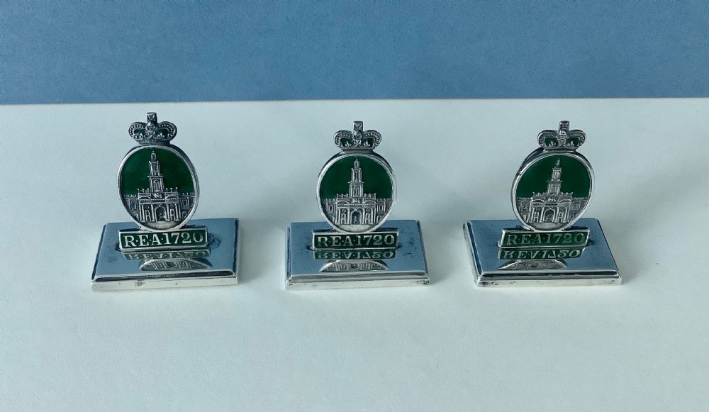 A set of three antique solid silver and green enamel menu holders featuring a crowned crest and rectangular bases. View III