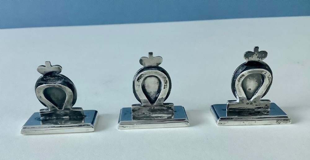 A set of three antique solid silver and green enamel menu holders featuring a crowned crest and rectangular bases. View V