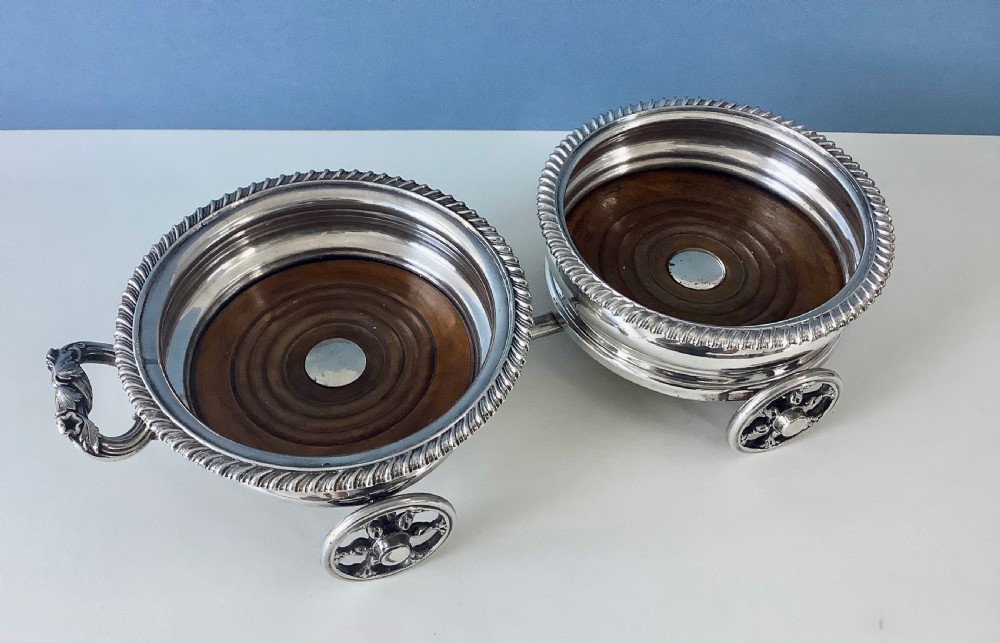A Georgian Old Sheffield Plate double wine coaster trolley featuring two gadrooned circular holders joined on a wheeled frame with a small end handle. View V