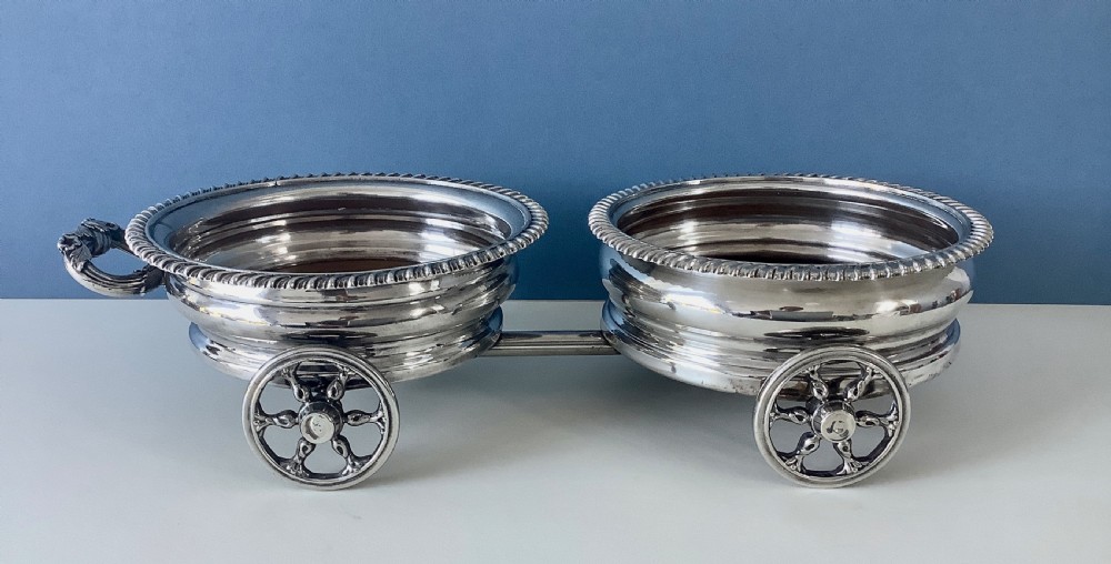 A Georgian Old Sheffield Plate double wine coaster trolley featuring two gadrooned circular holders joined on a wheeled frame with a small end handle. View VIII